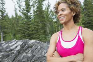 pretty, female runner pausing in the woods